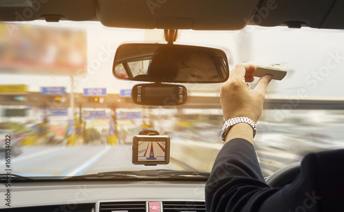 Canvas Print Man driving car using navigator and holding electronic toll collection system de