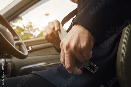 Man putting car seat belt before driving, close up at belt buckle, safe drive concept