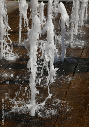 sparkling fountain splashes in summer in a city