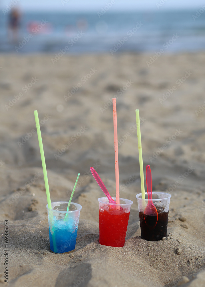 plastic glasses on the beach with sweet syrup called GRANATINA i plastic glasses on the beach with sweet syrup called GRANATINA i