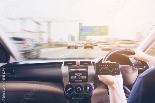 Man driving car on tollway road while looking stock report his mobile phone dangerously