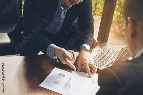 Two businessman discussing their chart in coffee shop