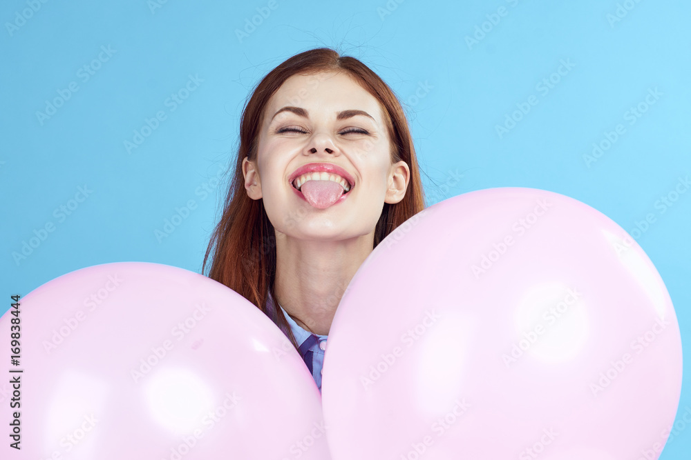 woman holds pink balloons and shows tongue, portrait woman holds pink balloons and shows tongue, portrait