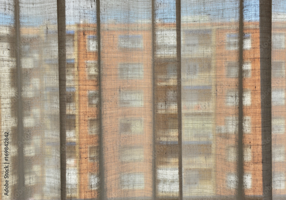 The building across the street through the curtains