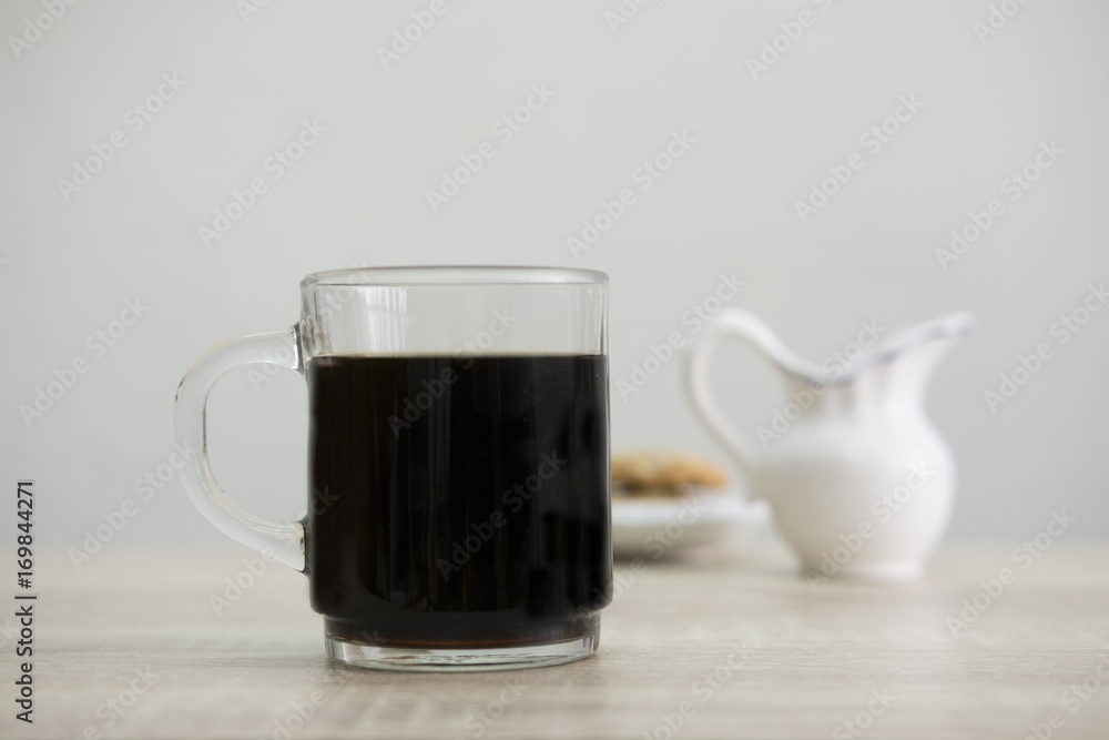 COFFEE MUG AND MILK JAR
Coffee in a transparent cup with milk jar and cookies on the wood table. COFFEE MUG AND MILK JAR
Coffee in a transparent cup with milk jar and cookies on the wood table.