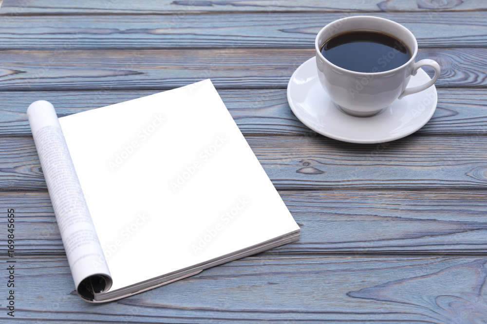 Mock-up magazine or a blue wooden table. A cup of coffee. On wood background. Blank page or notepad for mockups or simulations. Mock-up magazine or a blue wooden table. A cup of coffee. On wood background. Blank page or notepad for mockups or simulations.