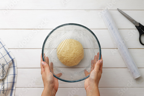 Step by step recipe galette or pie with nectarines. Female hands cover the dough with plastic wrap. photo