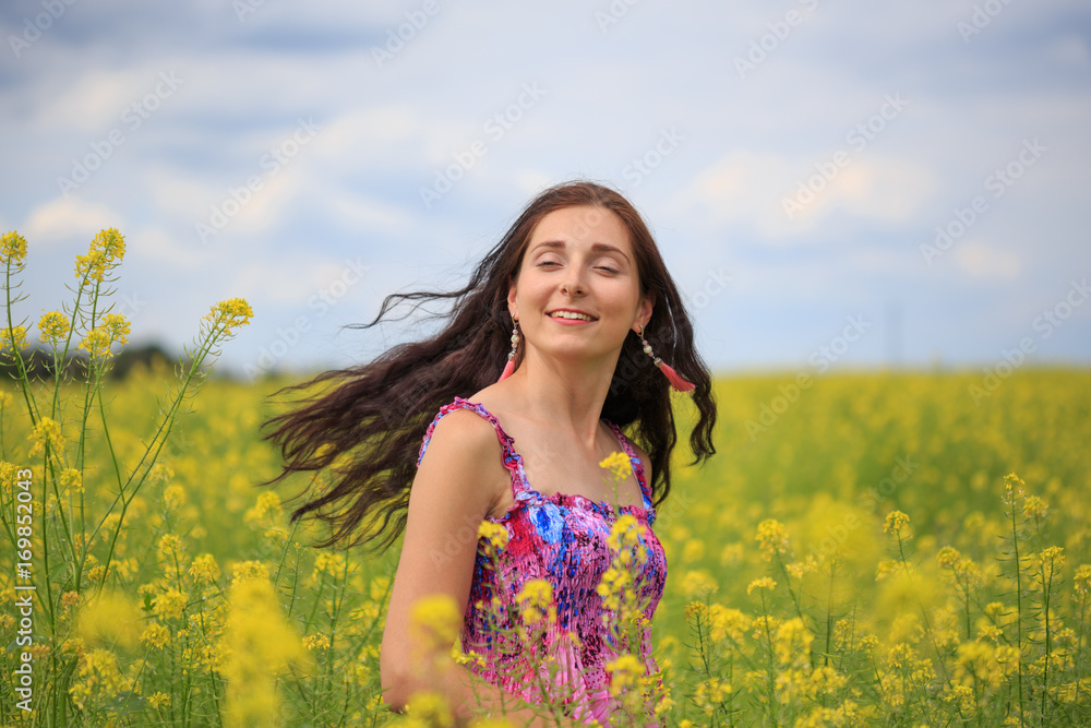 Woman with flying hair on yellow rape field Woman with flying hair on yellow rape field