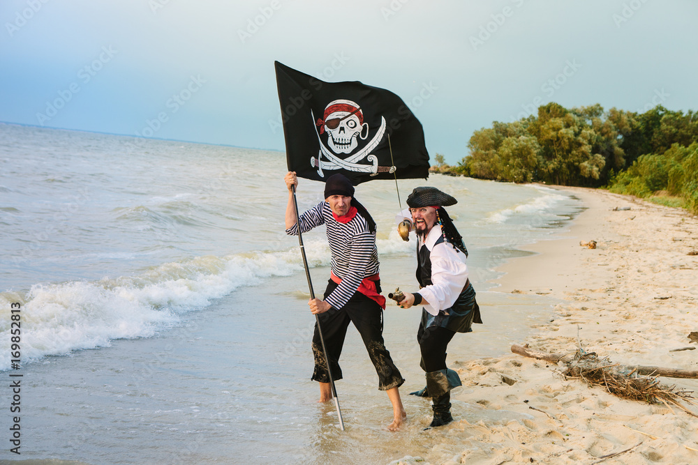 Naklejka premium Two pirates with a flag on the seashore