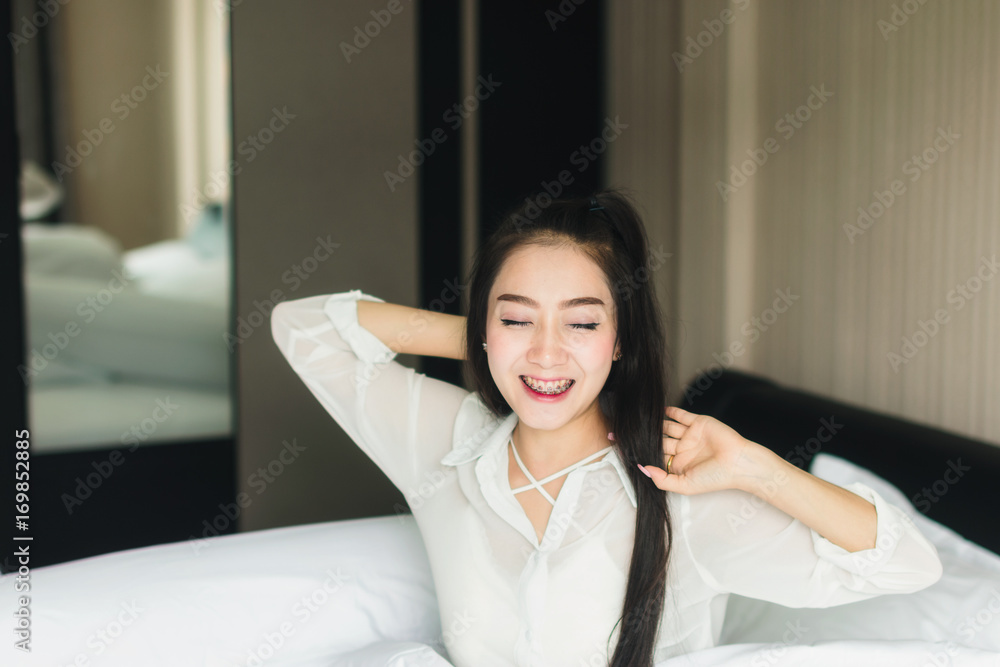 Beautiful Asian woman wearing white dress looking good Relax in the bedroom. Beautiful Asian woman wearing white dress looking good Relax in the bedroom.