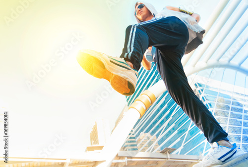 Man in sportswear jumping in front of urban buildings © praisaeng