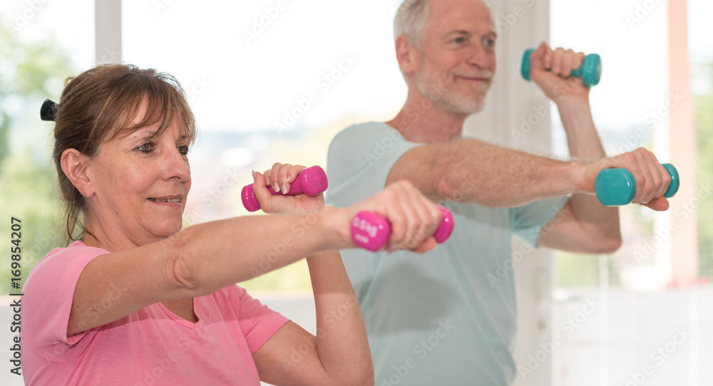 Senior couple exercising with dumbbells Senior couple exercising with dumbbells