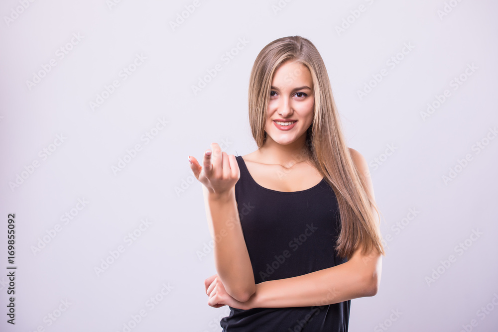 Happy pretty young woman standing and pointing at camera over gray background Happy pretty young woman standing and pointing at camera over gray background
