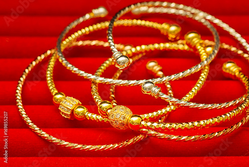 Collection of golden bracelet on red background