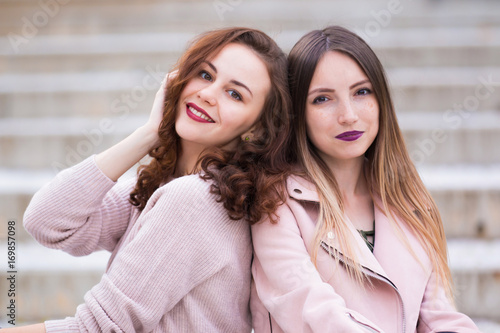 Two beautiful young women having fun on street of the city