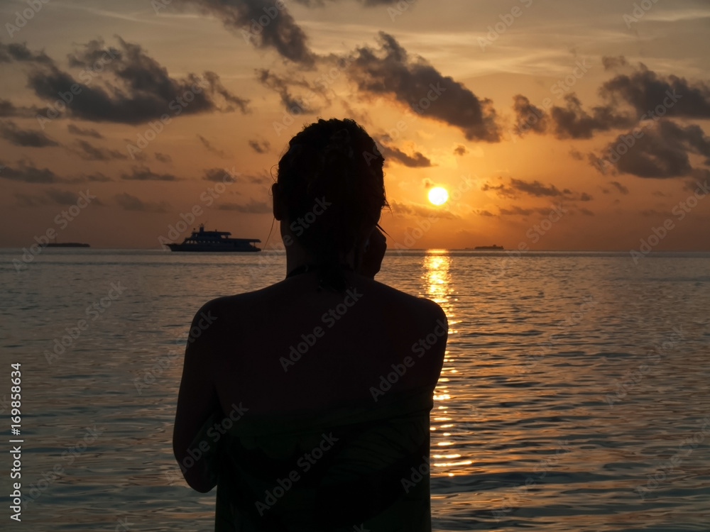 Silhouette of woman on the beach at sunset