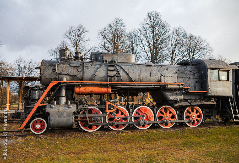 Old vintage steam locomotive from XX century, black and red color. Russian empire and USSR