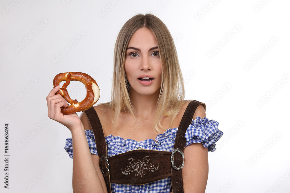 Hübsche blonde Frau mit Tracht und Brezel schaut überrascht Hübsche blonde Frau mit Tracht und Brezel schaut überrascht