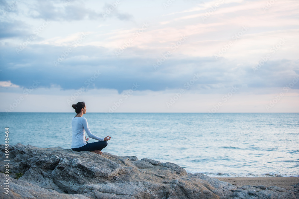 Beautiful woman practicing yoga on the beach at sunrise Beautiful woman practicing yoga on the beach at sunrise