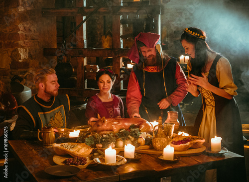 Bild auf Leinwand Medieval people eat and drink in castle tavern.