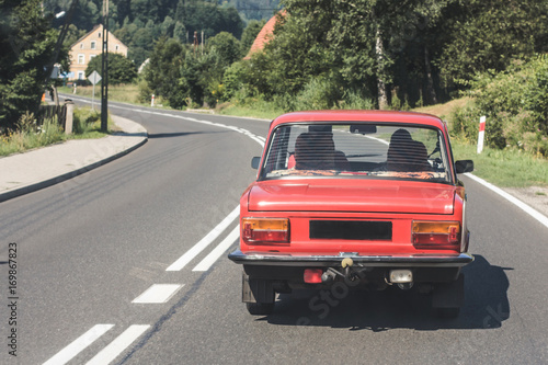 Old red retro car on the road. © Paweł Michałowski