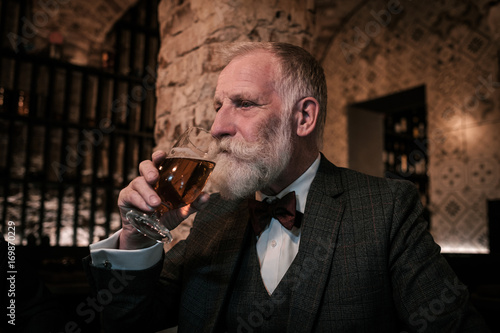Obraz na plátně Senior gentleman tasting craft beer