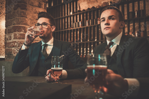 Fotografia Young gentlemen tasting craft beer