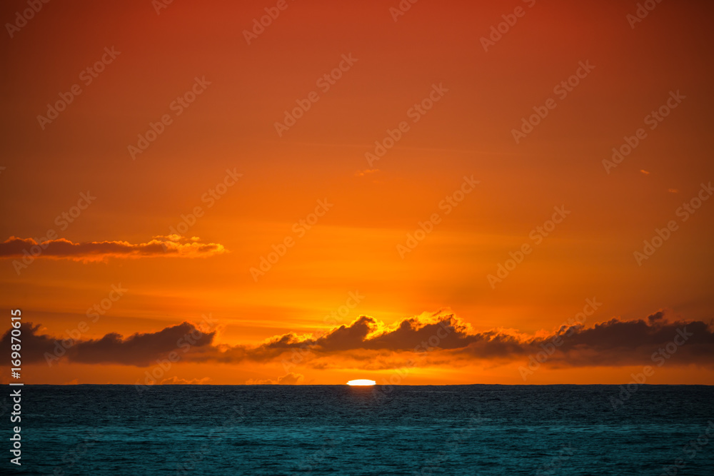 Last sun in ocean. Water surface under red sky