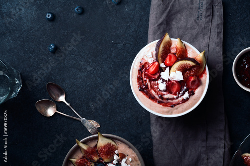 Almond milk bowl with strawberries and figs. Dark food phorography concept. Flatlay with copy space photo