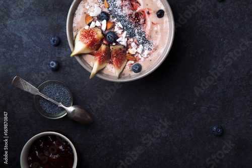 Blueberry banana smoothie bowl with figs and coconut. Dark food phorography concept. Flatlay with copy space photo