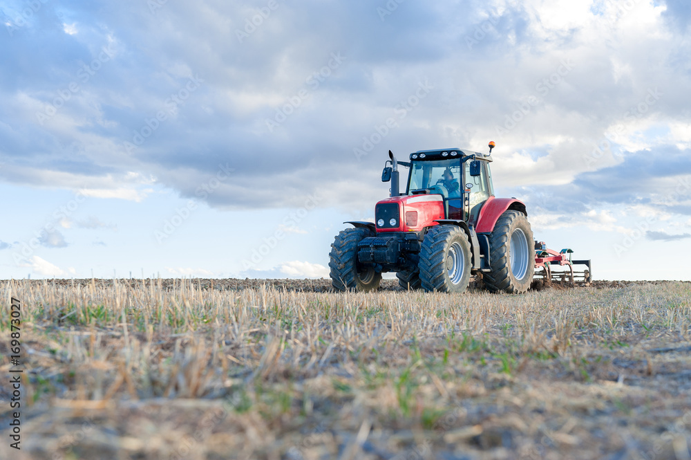 agricultural tractor in the foreground with blue sky background. agricultural tractor in the foreground with blue sky background.