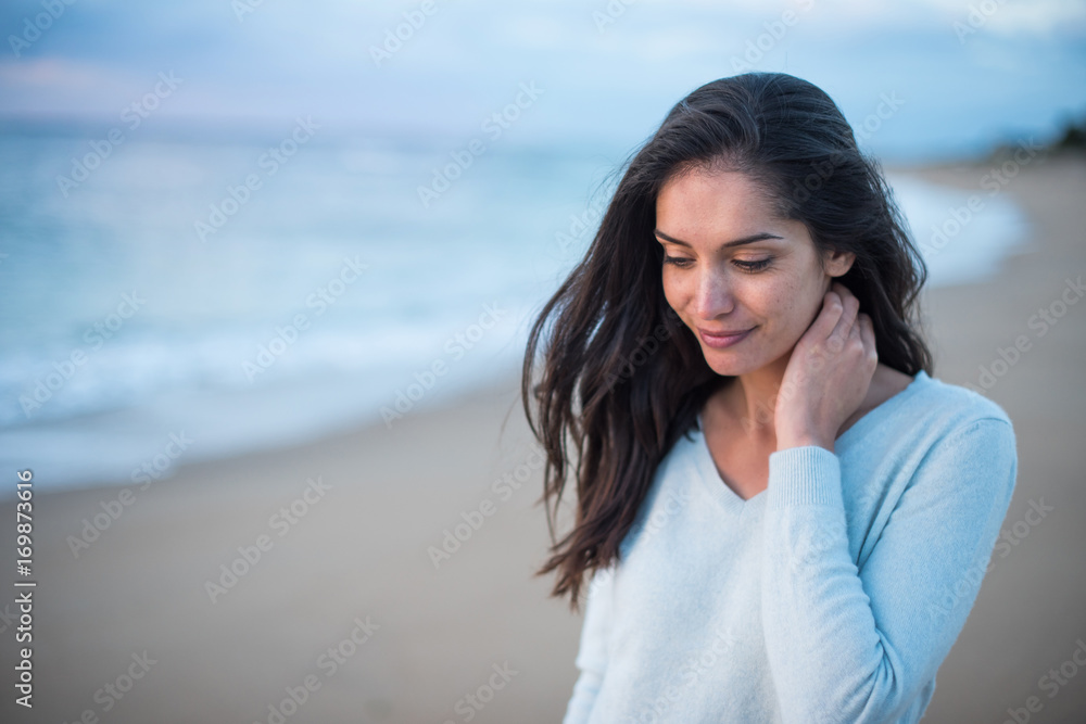 Portrait of a brunette with long hair walking on the beach Portrait of a brunette with long hair walking on the beach