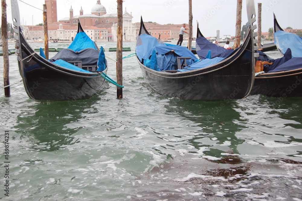  Gondolas docked on the Grand Canal near San Marco with St Giorgio in the background. Venice. Italy 