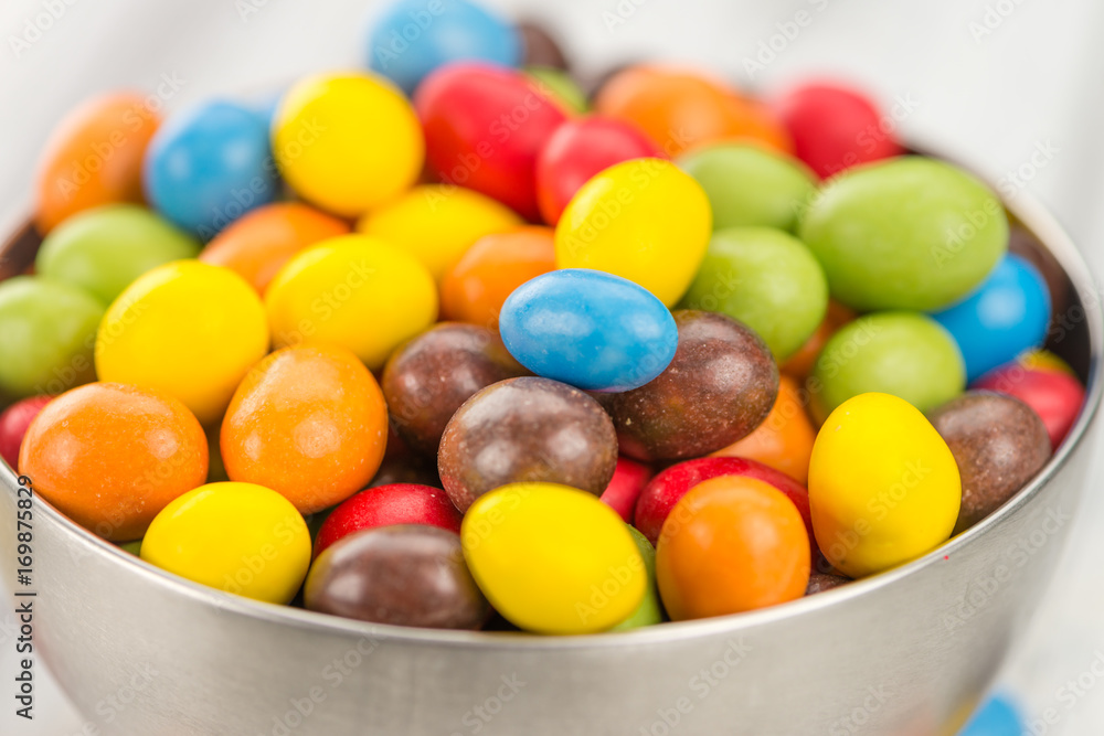 Portion of Cocolate coated Peanuts on wooden background (selective focus) Portion of Cocolate coated Peanuts on wooden background (selective focus)