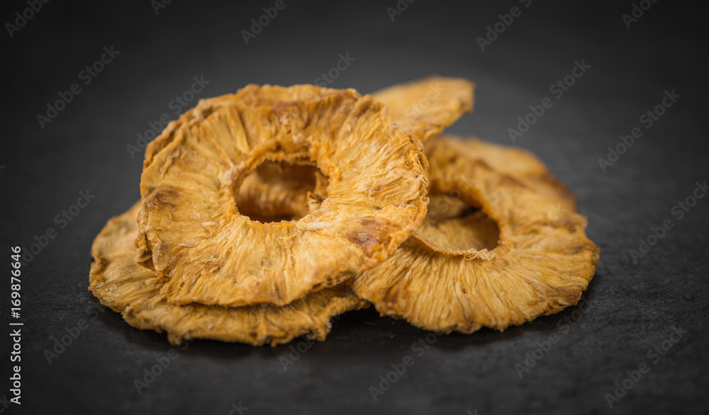 Some Pineapple rings (dried) on a dark slate slab Some Pineapple rings (dried) on a dark slate slab