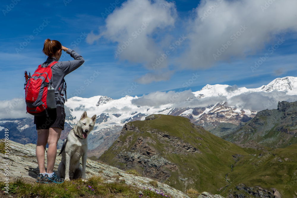donna che guarda panorama in montagna con cane