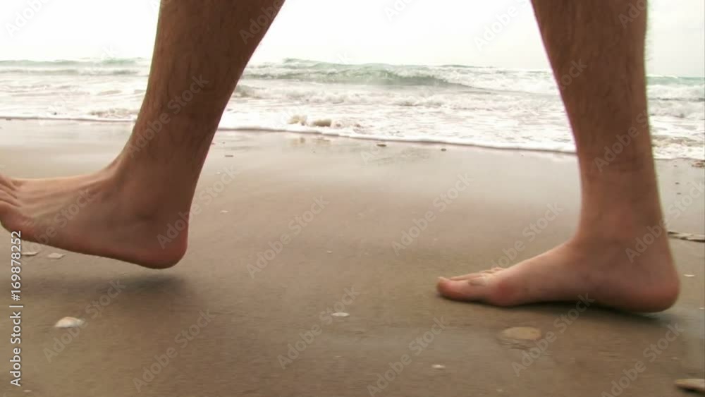 CU guy's feet walking on beach CU guy's feet walking on beach