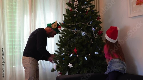 Father and daughter undoing the Christmas tree together, selective focus