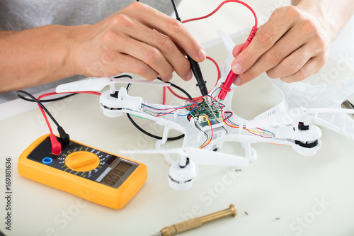 Man Testing Electric Current Of Drone Using Multimeter Tool