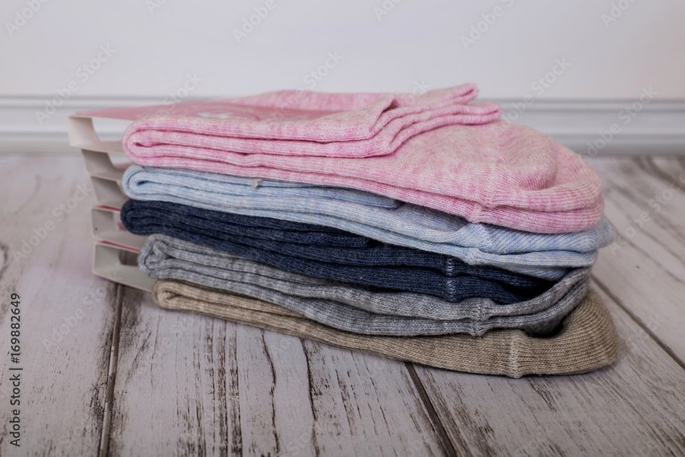 A stack of female socks. Women's cotton socks on wooden background.
A stack of female socks. Women's cotton socks on wooden background.