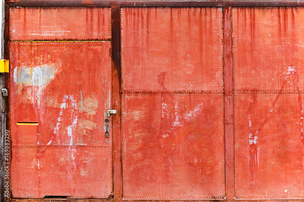 Old rusty red steel front gate security door with three heavy metal padlocks Old rusty red steel front gate security door with three heavy metal padlocks