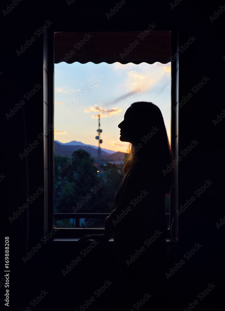 Woman silhouette near window