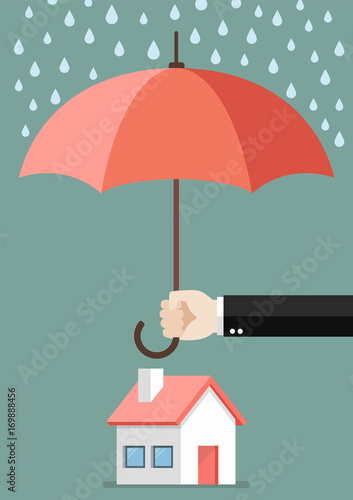 Hand holding an umbrella protecting house