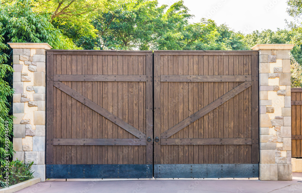 Wooden gates with stone columns. The design is vintage style. Wooden gates with stone columns. The design is vintage style.