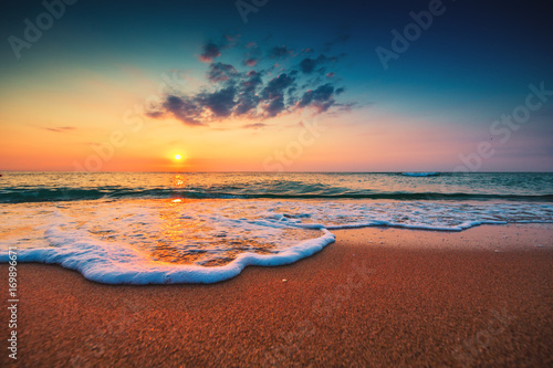 Beautiful sunrise over the sea and splashing waves