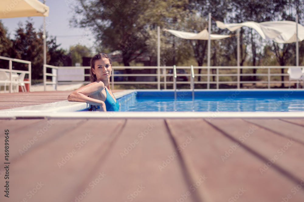 one young adult woman, posing, relaxing swimming pool edge, water, looking to camera, wet long hair, hot sunny day outdoors, harsh sunlight, wood floor