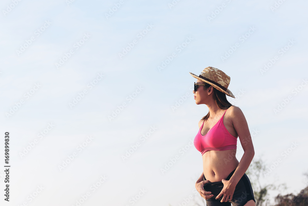 Asian smiling young female model in bikini standing . Woman having fun out on a summer day.