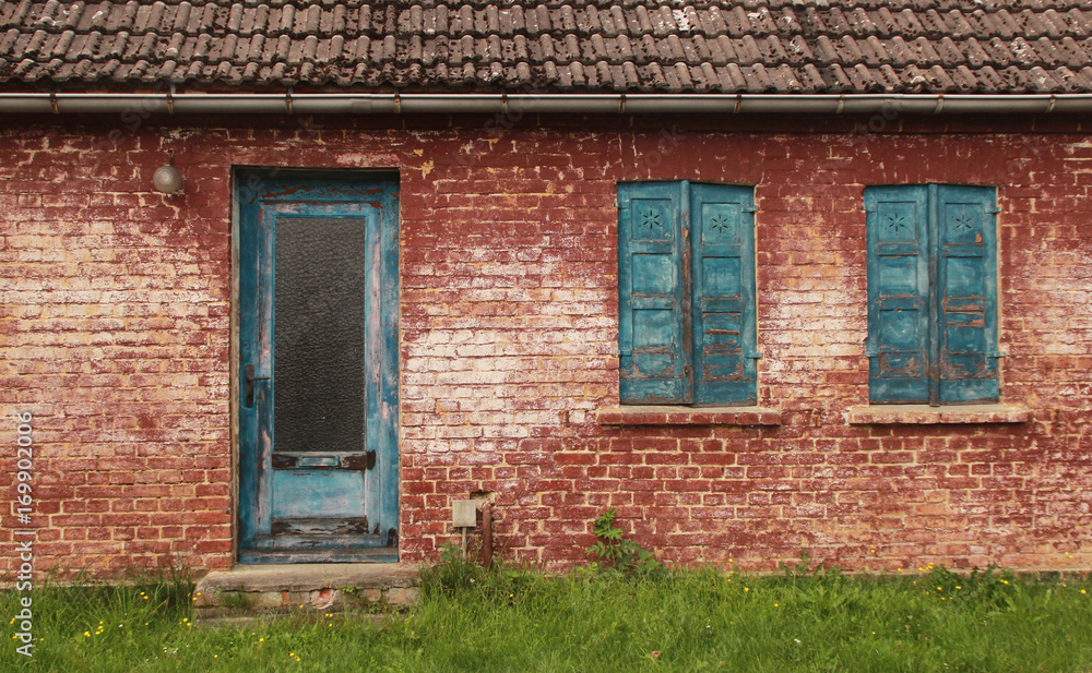 altes Ziegelhaus mit verwitterten Türen und Fenstern