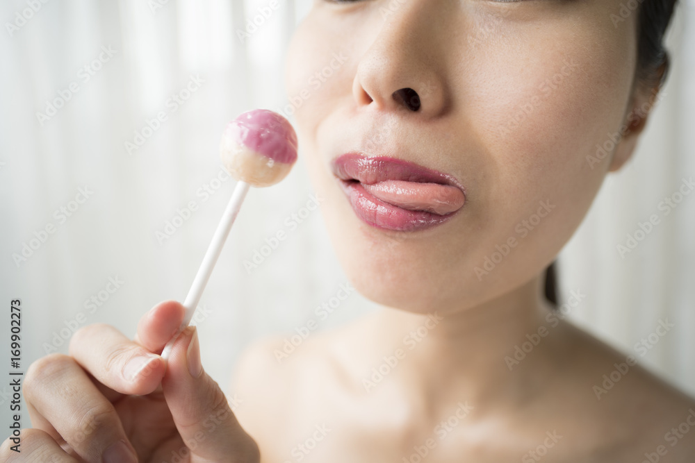 A woman is licking a candy deliciously A woman is licking a candy deliciously