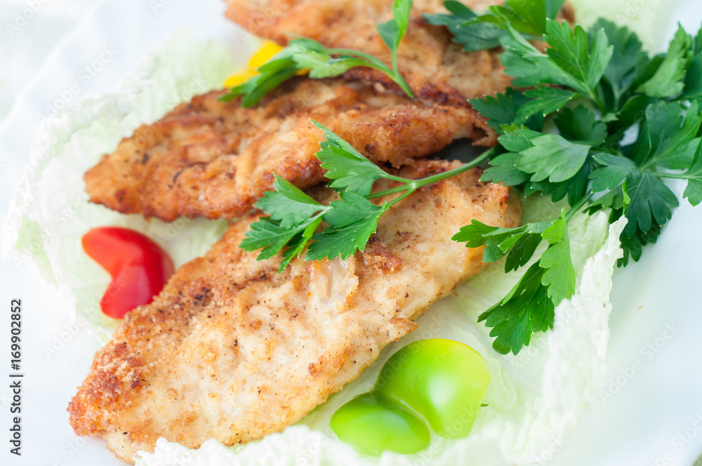 fish in batter with greens on a white plate